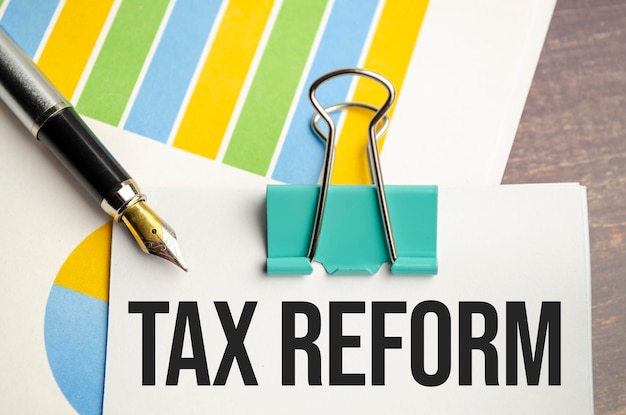 Witte notitiebloktekst TAX REFORM met diagram en pen