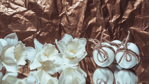 Witte paaseieren met bloemen op gouden achtergrond close-up