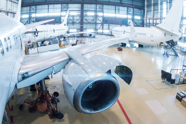 Witte passagiersvliegtuigen in de hangar Mechanische systemen controleren voor vluchtoperaties