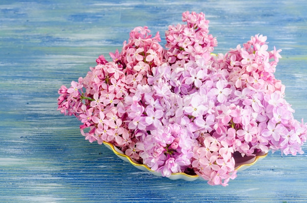 Witte plaat met lila bloemen op tafel.