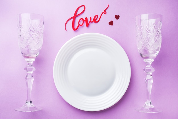Witte plaat, twee glazen inscriptie liefde. Concept Valentijnsdag.
