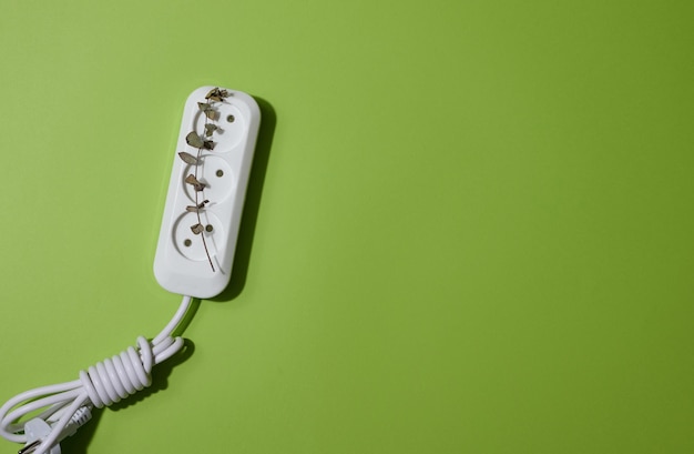 Witte plastic aansluiting met kabel op een groene achtergrond bovenaanzicht