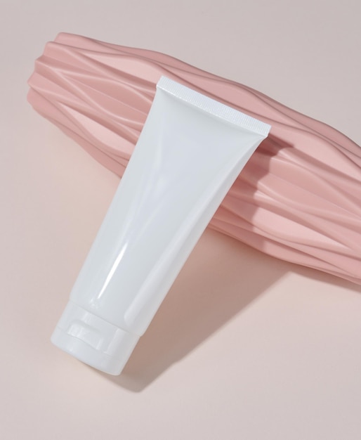 Witte plastic buis voor vloeibare cosmetica op een beige achtergrondverpakking