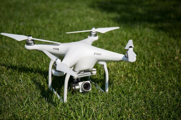 Witte plastic drone close-up na het testen van de vlucht landde op het gras