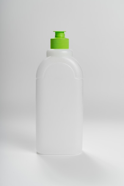 Witte plastic fles met een groene kurk op een witte achtergrond. het concept van het recyclen van plastic. vloeistoffen container.