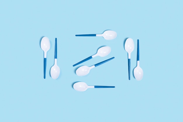 Witte plastic lepels op blauwe achtergrond