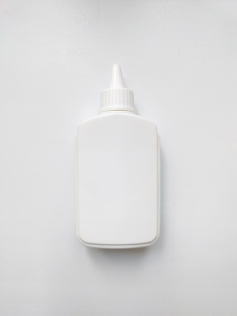 Witte plastic lijm fles geïsoleerd op een witte achtergrond.