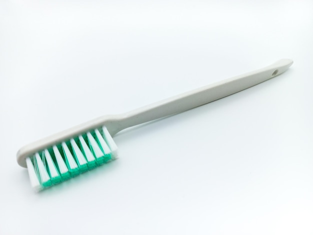 Foto witte plastic tandenborstel gekanteld geïsoleerd op een witte achtergrond