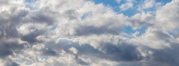 Witte pluizige wolken bedekken dicht de blauwe lucht, panorama