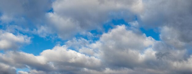 Witte pluizige wolken bedekken dicht de blauwe lucht