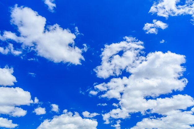 Witte pluizige wolken in diepblauwe lucht