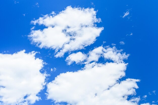 Witte pluizige wolken in een diepblauwe lucht