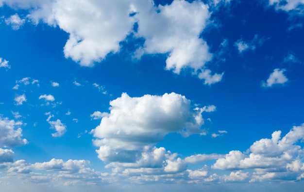 Witte pluizige wolken met regenboog in de blauwe lucht