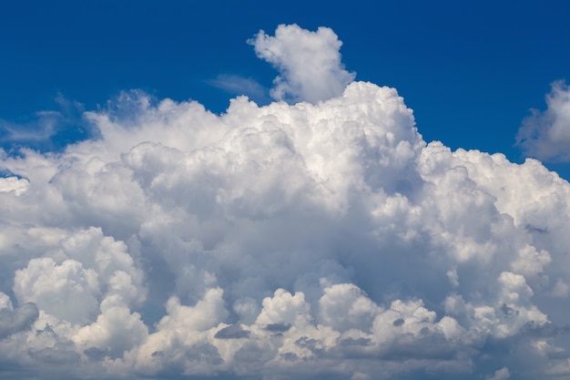 Witte pluizige wolken op de blauwe hemelachtergrond