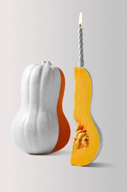 Witte pompoen met een gesneden stuk met een kaars erop op een witte achtergrond Pumpkin Cake Concept