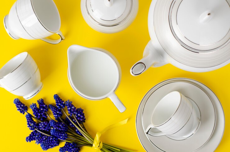 Witte porseleinen koffie- of theeset met muscari-bloemen op geel