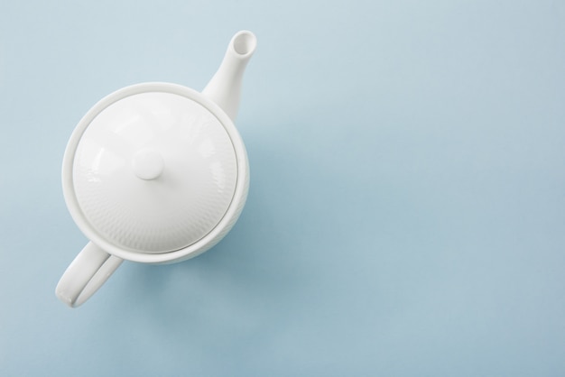Witte porseleinen theepot op blauw. Bovenaanzicht