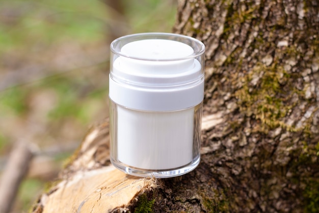 Witte pot met cosmetica op de schors van een boom in de natuur