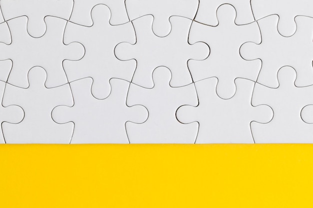 Witte puzzelstukjes op een gele achtergrond Bedrijfsoplossingsconcept