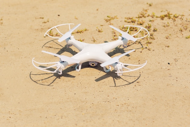 Witte quadrocopter op zand, close-up