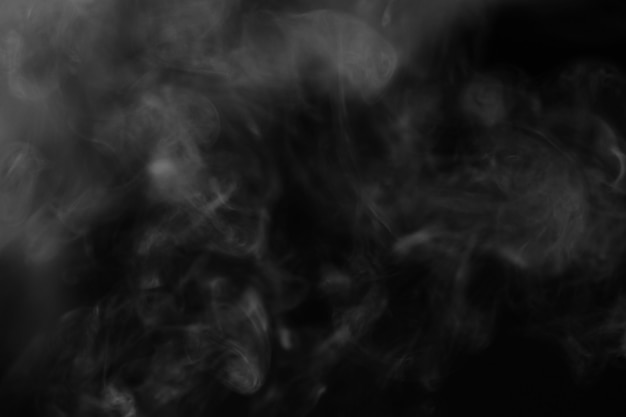 Witte rook op een zwarte achtergrond. Textuur van rook. Clubs van witte rook op een donkere achtergrond voor overlay