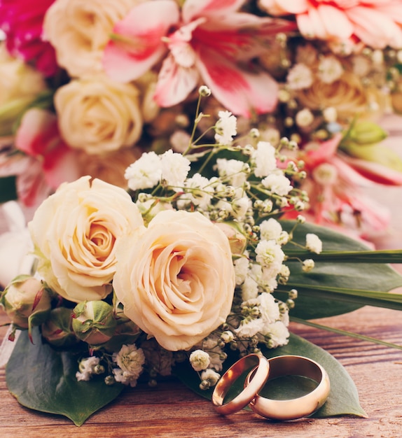 Foto witte rozen en trouwringen op houten textuur