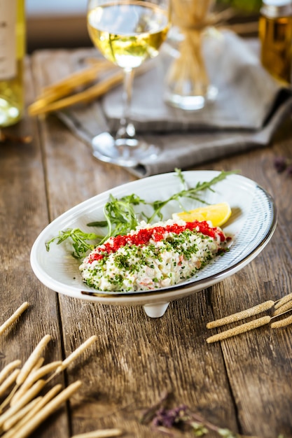 Witte salade met rode kaviaar tobiko en groene ui