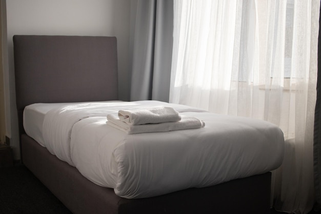Witte schone handdoeken gestapeld op het hotelbed. Hoge kwaliteit foto