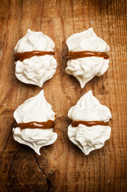 Witte schuimgebakjes op een witte achtergrond in een bovenaanzicht