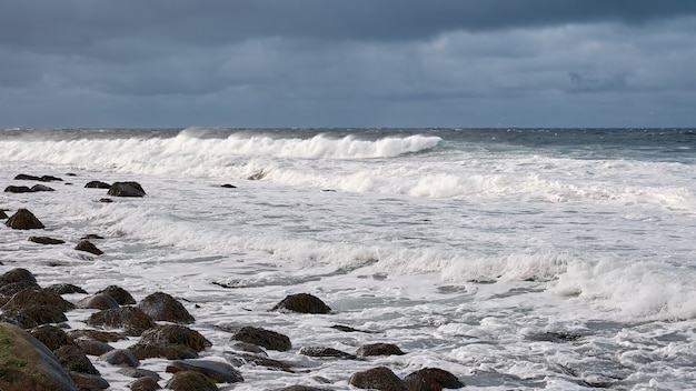 Witte schuimgolven lopen op de rotsachtige kust van de witte zee Noordse Barentszzee oceaan