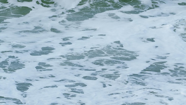 Witte schuimgolven op de kust zand zandstrand schuim zee surf langzame beweging