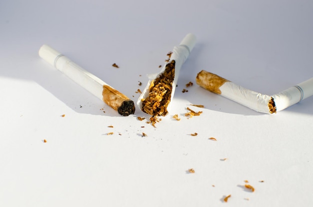 Witte sigaretten al gerookt, niet roken en tabak zichtbaar op wit oppervlak.
