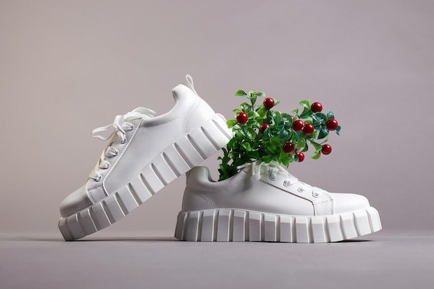 Witte sneakers en tak met bessen mode schoenen stilleven