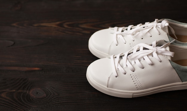 Witte sneakers op donkere houten achtergrond