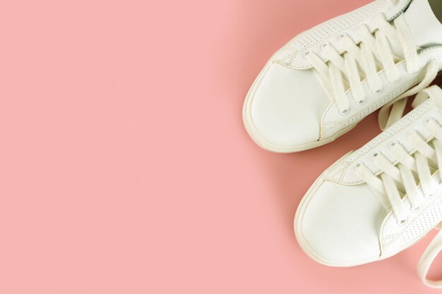 Witte sneakers op roze achtergrond