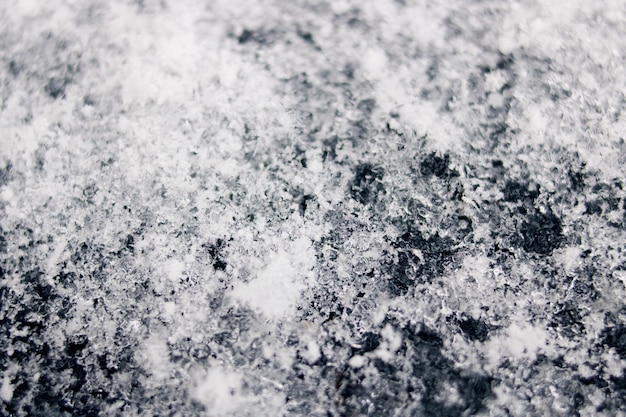 Witte sneeuwvlokken op zwarte oppervlakte macrofoto