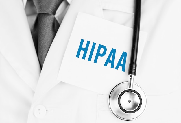Witte sticker met tekst HIPAA liggend op medische mantel met een stethoscoop