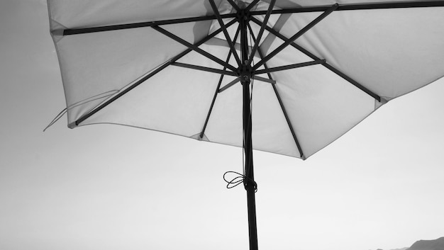 Witte stof kleur textuur parasol en bruin houten statief met witte wolk en heldere blauwe hemel zomer zonlicht dag in lage hoek camera voor reizen Azië Thailand Pattaya