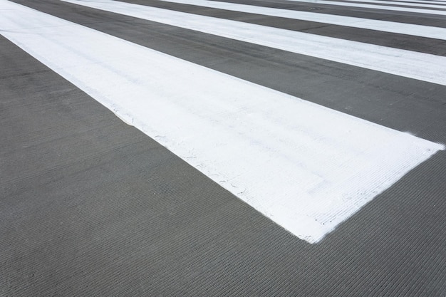 Witte strepen op grijze asfaltbetonmarkering