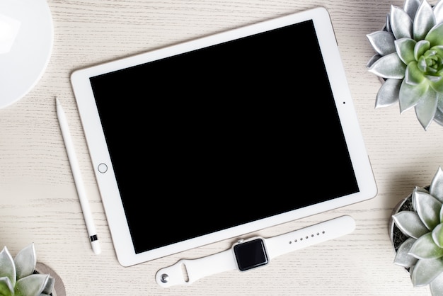 Witte tablet en kijk op een houten tafel