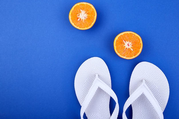 Witte teenslippers, oranje fruit, zeeschelp