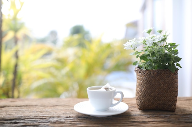 Witte theekop en Verbena plantenpot houten tafelbalkon