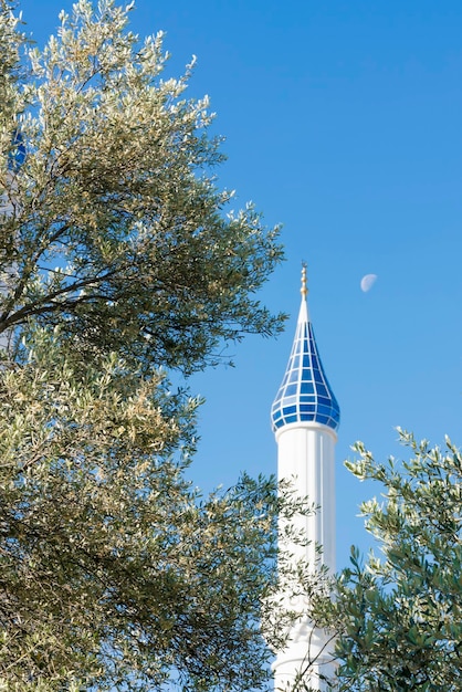 Witte toren van de moskee tegen de blauwe lucht