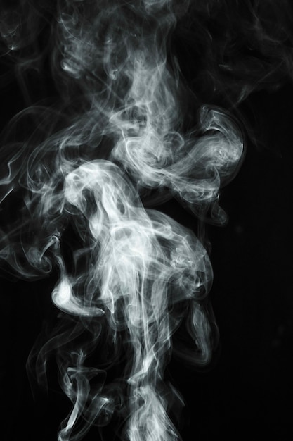 Witte transparante rook die over zwarte achtergrond blaast