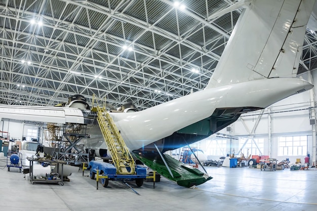 Foto witte transportvliegtuigen in de hangar mechanische systemen controleren voor vliegoperaties