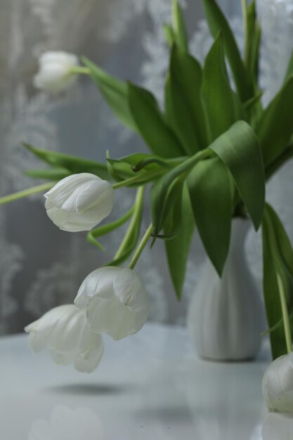 Witte tulpen in een boeket op een witte tafel