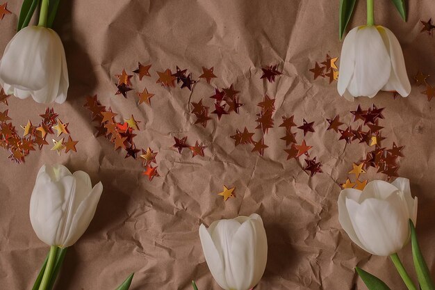 Witte tulpen op een bruine papieren ondergrond Tulpen Lentebloemen Boeket Foto voor een ansichtkaart