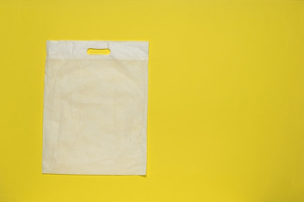 Witte verpakkingstas op een gele achtergrond.