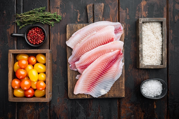 Witte visfilet, met basmatirijst en cherrytomaatjes ingrediënten, op oude houten tafel, bovenaanzicht