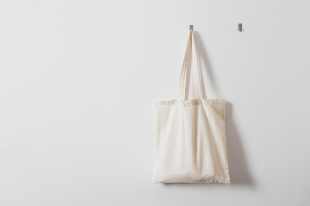 Foto witte voddenzak voor boodschappen herbruikbare tas vegetarisme raw food dieet bewuste consumptie zakdoek hangende witte stoffen tas aan een haak